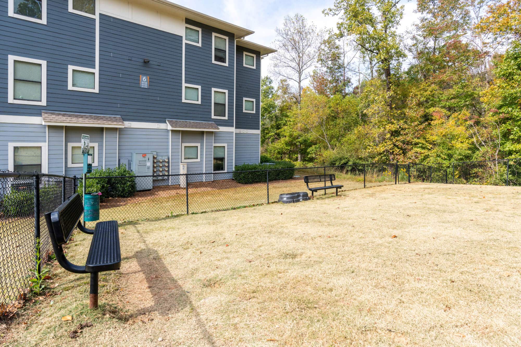 Dog park with benches and grass.